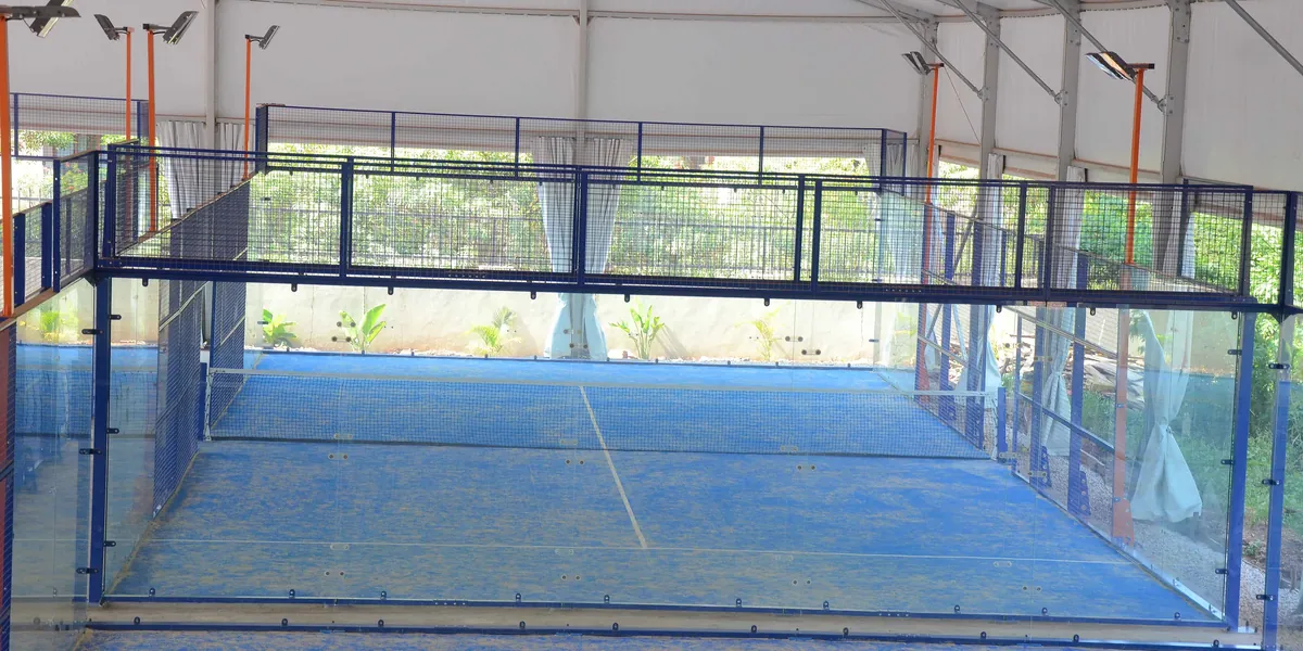 Un campo da padel coperto con pareti di vetro